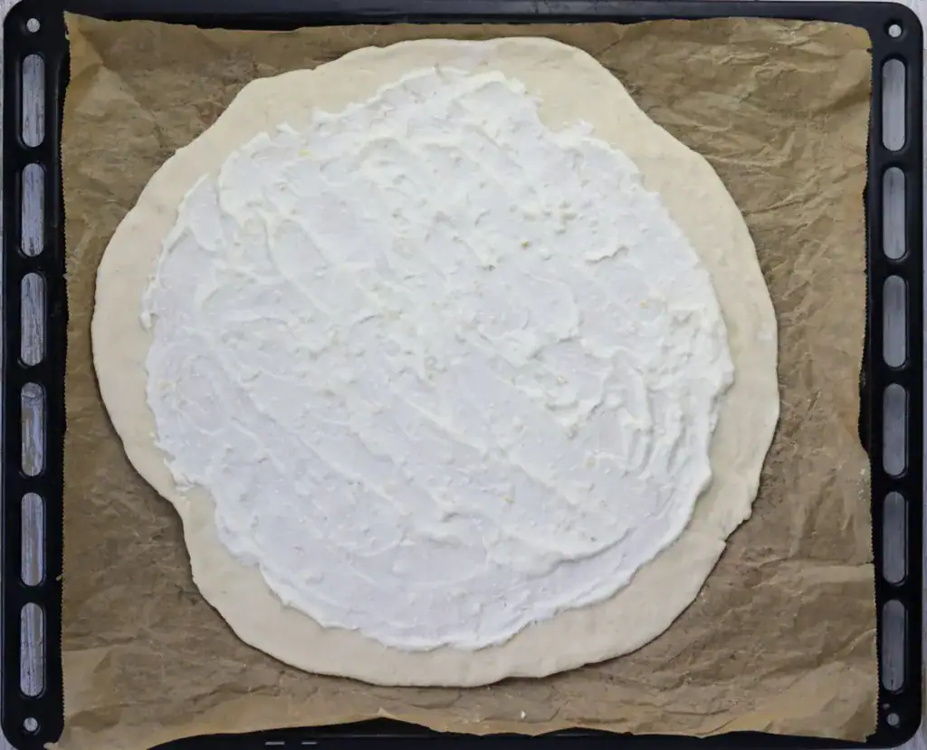 step 8: adding creamy garlic sauce to pizza dough