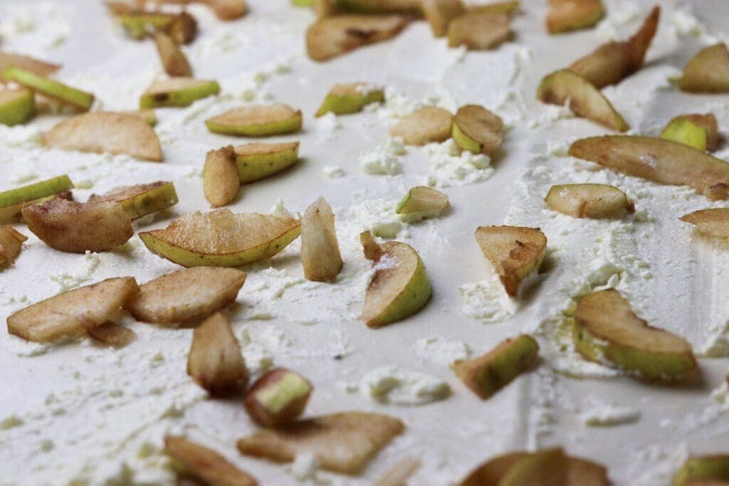Slices of pears tossed over a  large strudel phyllo dough sheet.