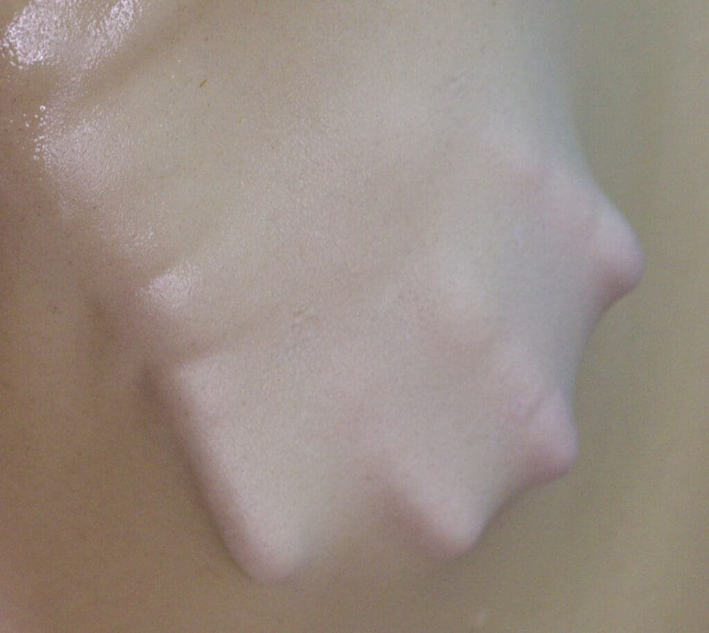 A thin sheet of homemade strudel phyllo dough, so thin, that the hand bellow the dough is completely visible. 