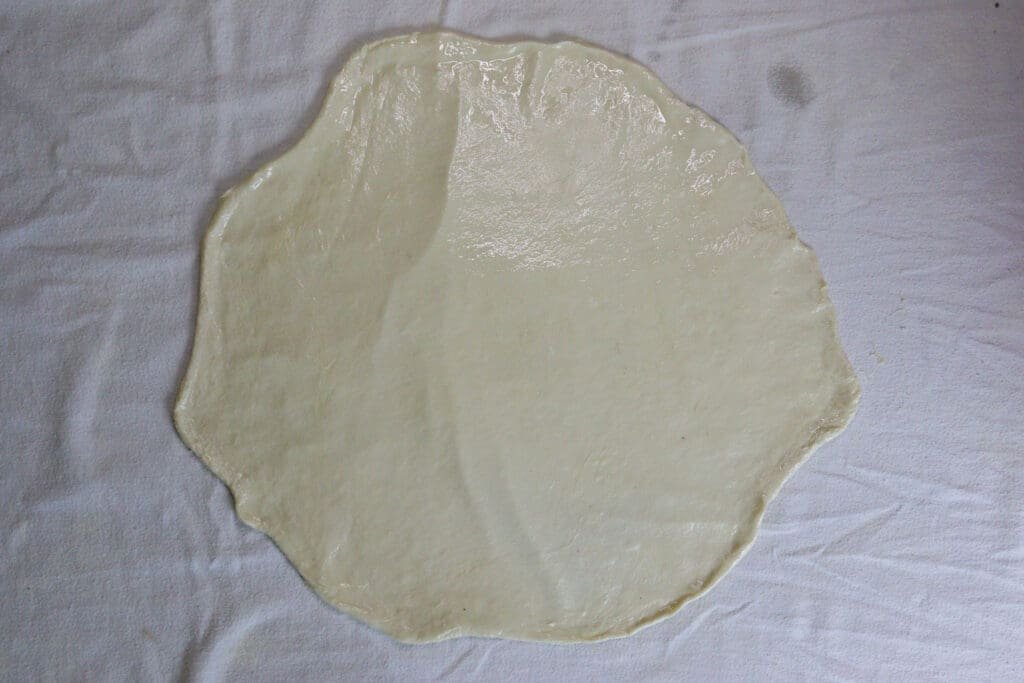 Oiling the rolled out strudel dough to make it stretch easier. 