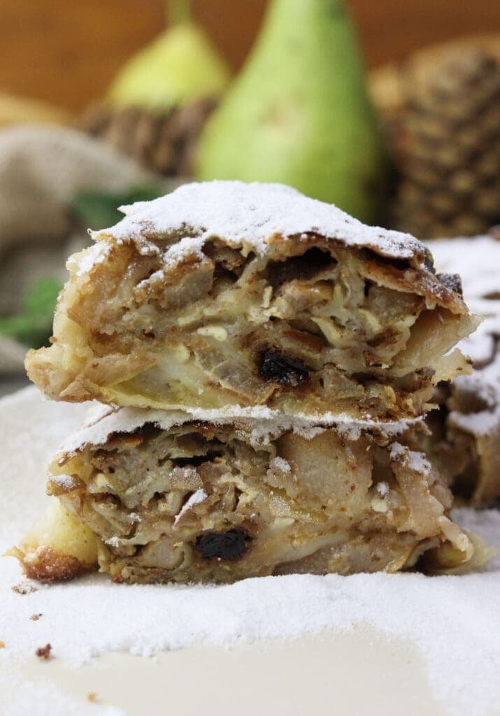 Two large slices of pear strudel stacked on top of each other. 