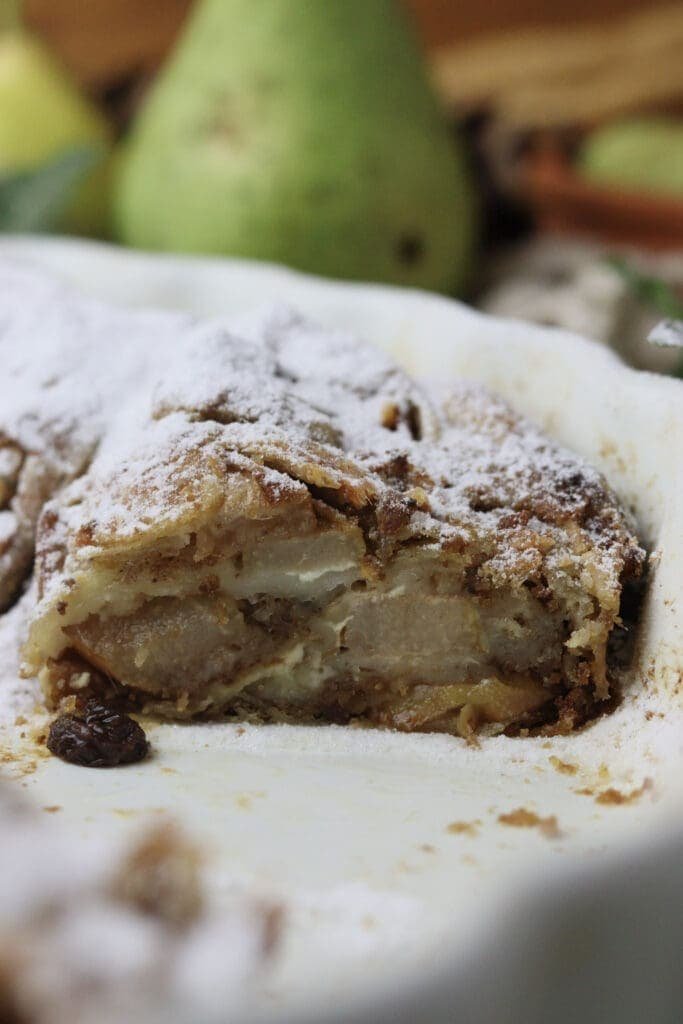 Sliced homemade pear strudel with cottage cheese, raisins and toasted breadcrumbs. 