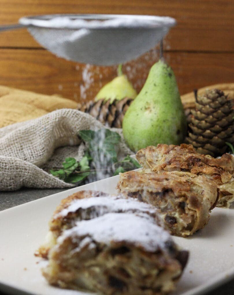 Powdering the strudel with dusted sugar. 