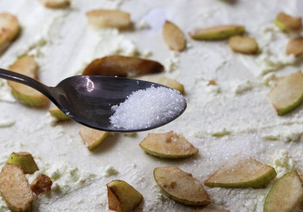 Pears on the phyllo strudel sheet, being sprinkled with sugar. 
