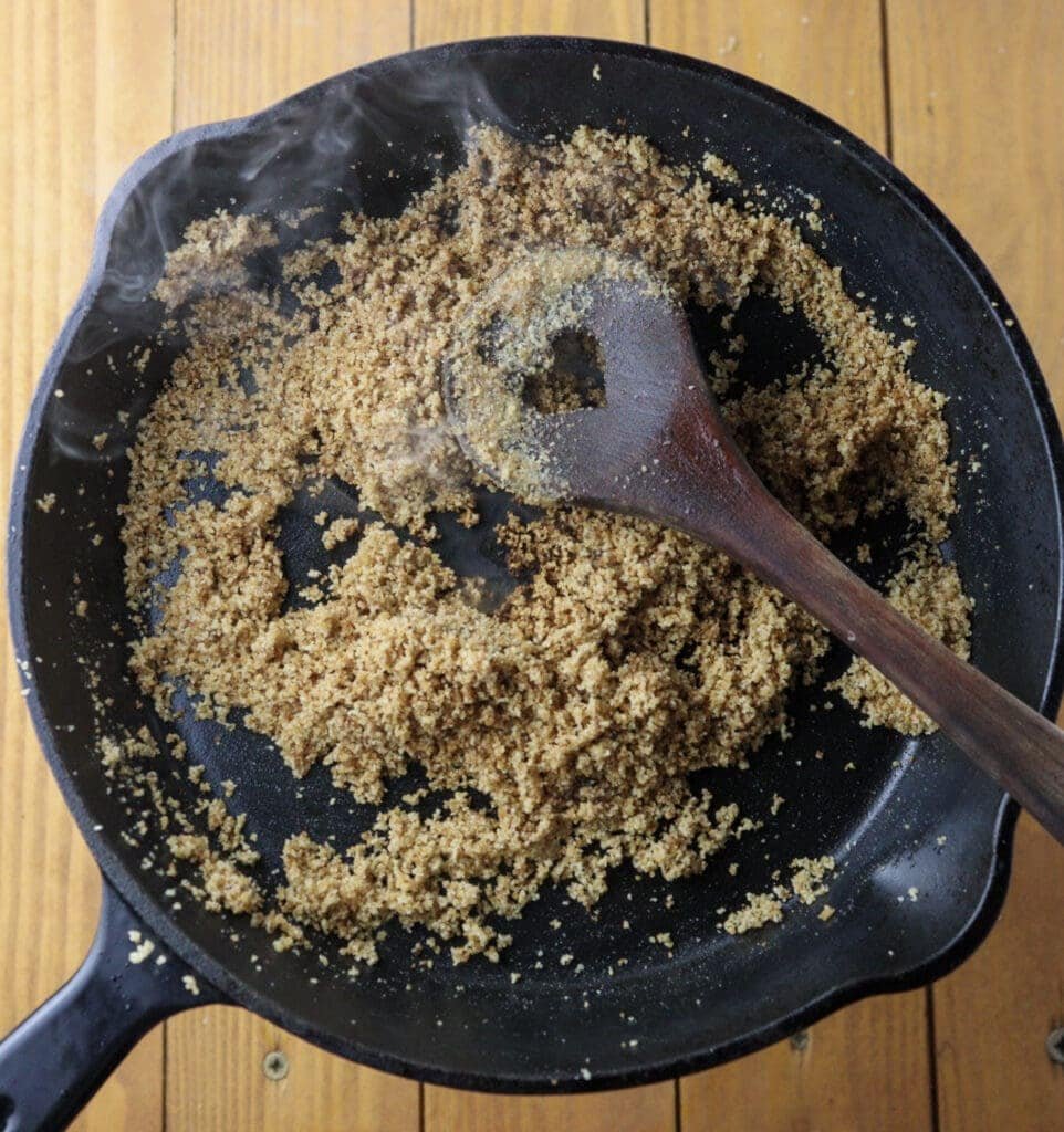 Toasting breadcrumbs on butter  in a frying pan.