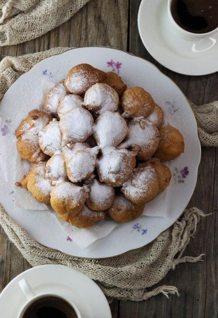 Ustipci sprinkled with powdered sugar and served with coffee.