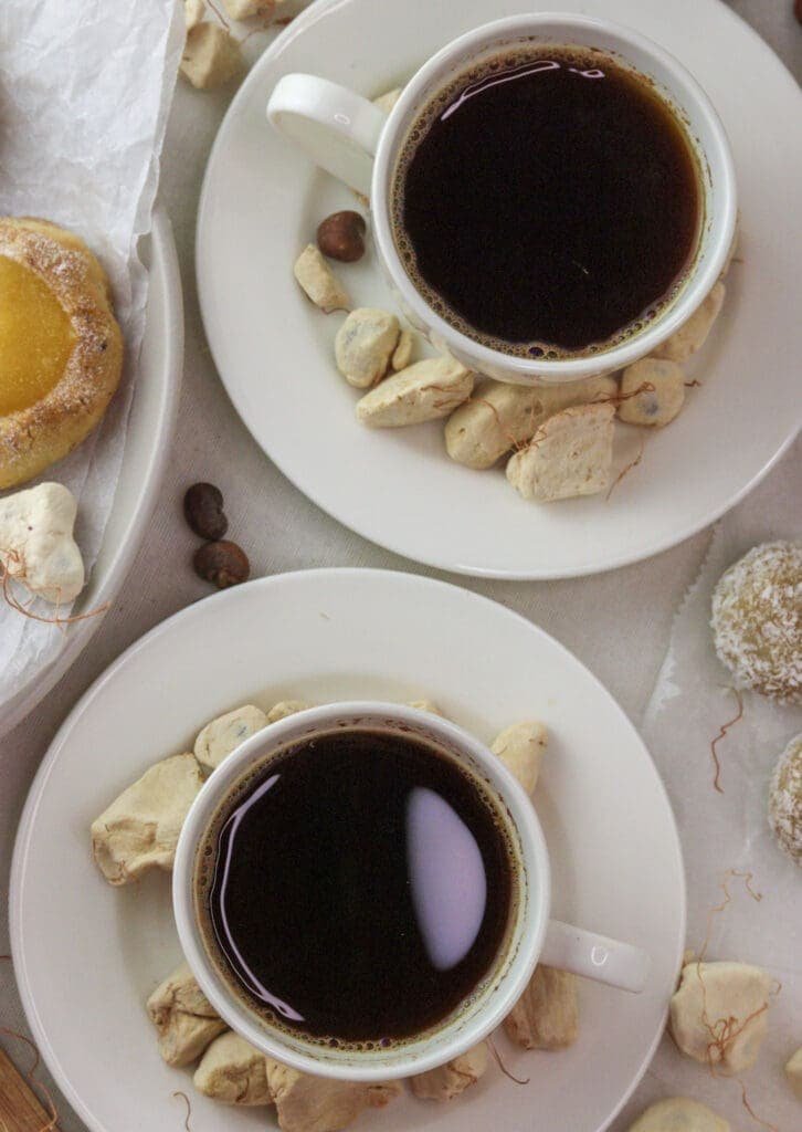 Two cups of baobab coffee served with baobab cookies and baobab bites. 