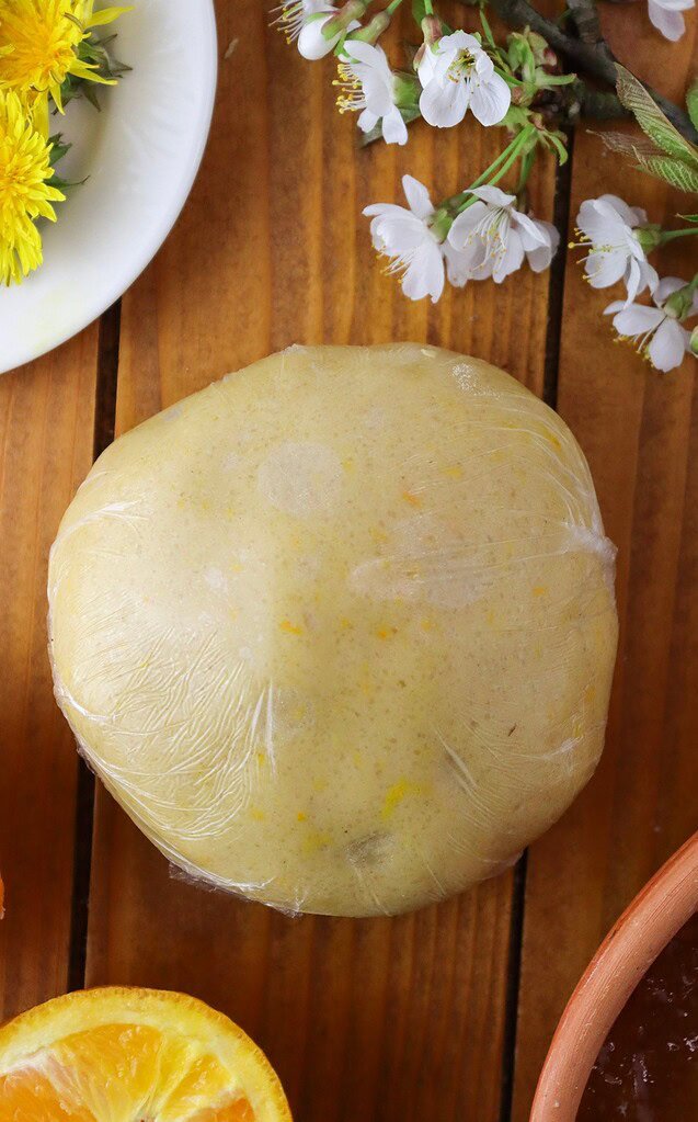Large ball of cookie dough wrapped in plastic foil, ready to chill in the fridge.