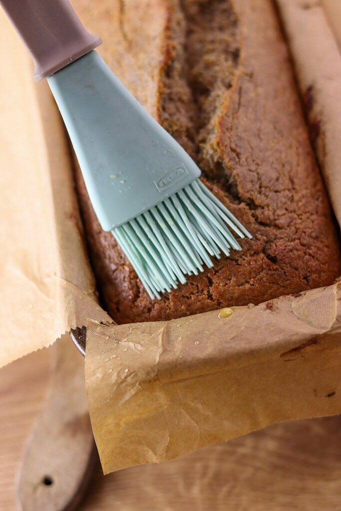 Brushing fresh dandelion buckwheat bread with honey and warm water. 