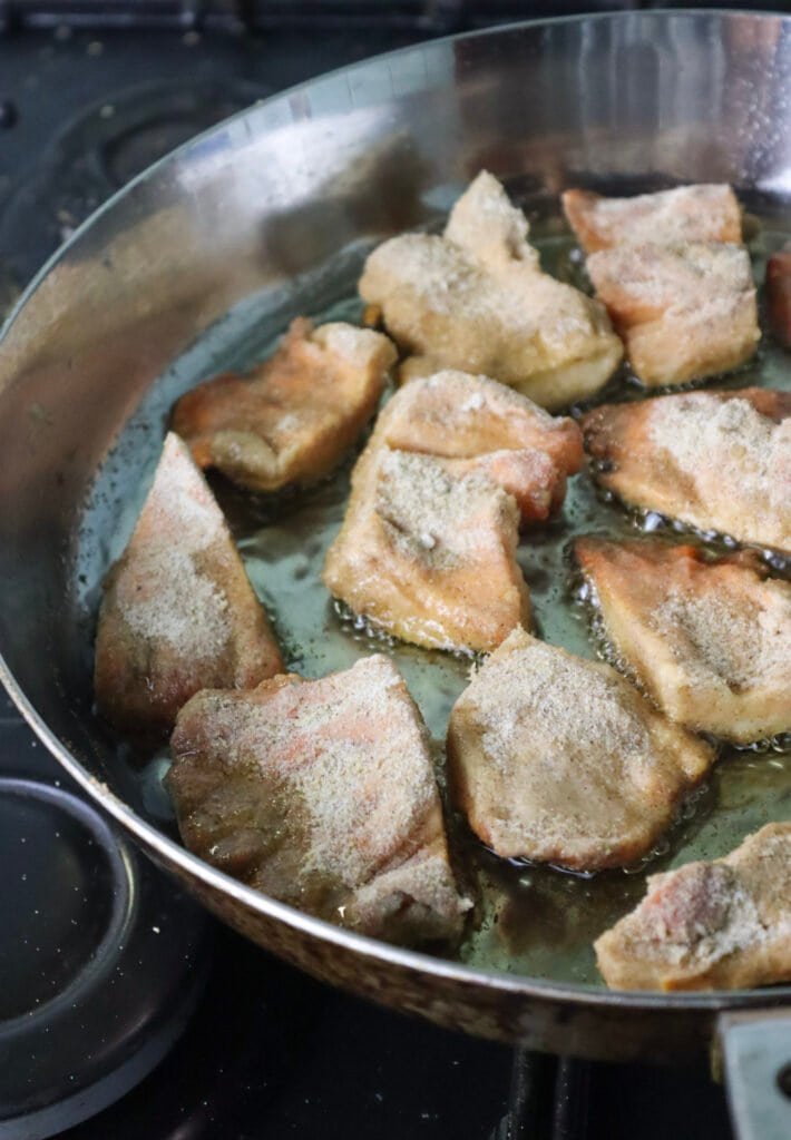 Frying mushroom slices in olive oil in a frying pan.