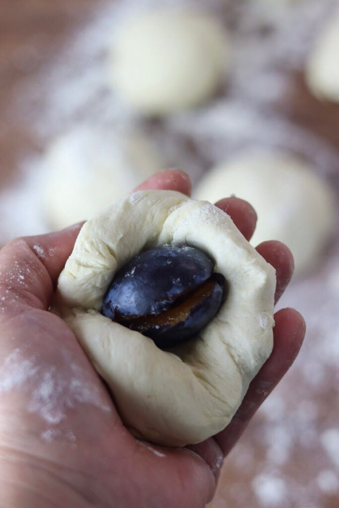 How to place a fresh plum in the spelt dough to form a plum dumpling.