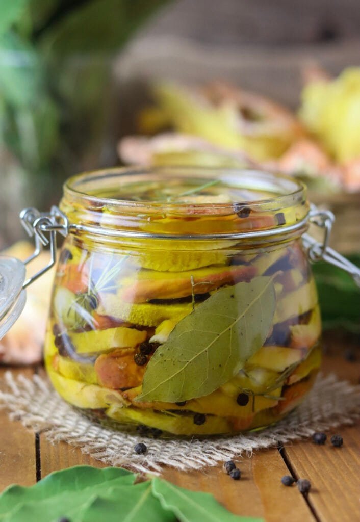 Pickled chicken of the woods mushroom recipe, stuffed in a mason jar with a bay leaf and pepper.
