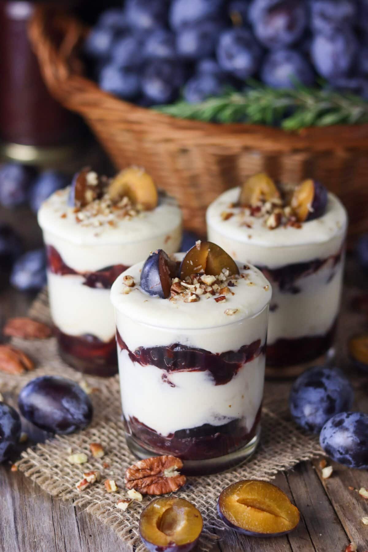Roasted plum parfait with white chocolate on a wooden rustic table.