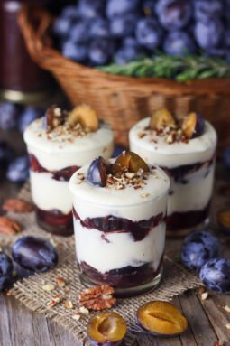 Roasted plum parfait with white chocolate on a wooden rustic table.