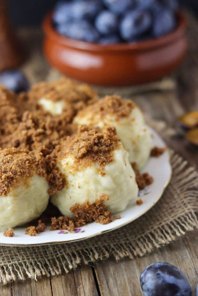 Dessert dumplings filled with fresh plums in a cottage cheese and spelt flour coating, covered with breadcrumbs. Served with honey and cinnamon.