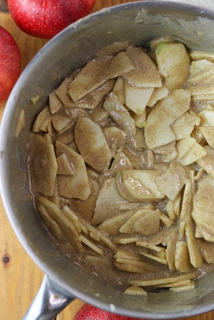 Mixing apple slices with buckwheat batter in a large bowl.