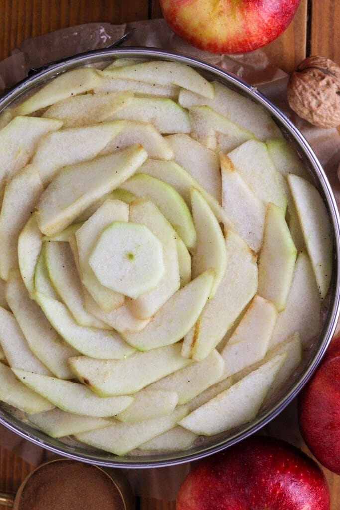 Topping the cake batter with thin slices of apples and pears.