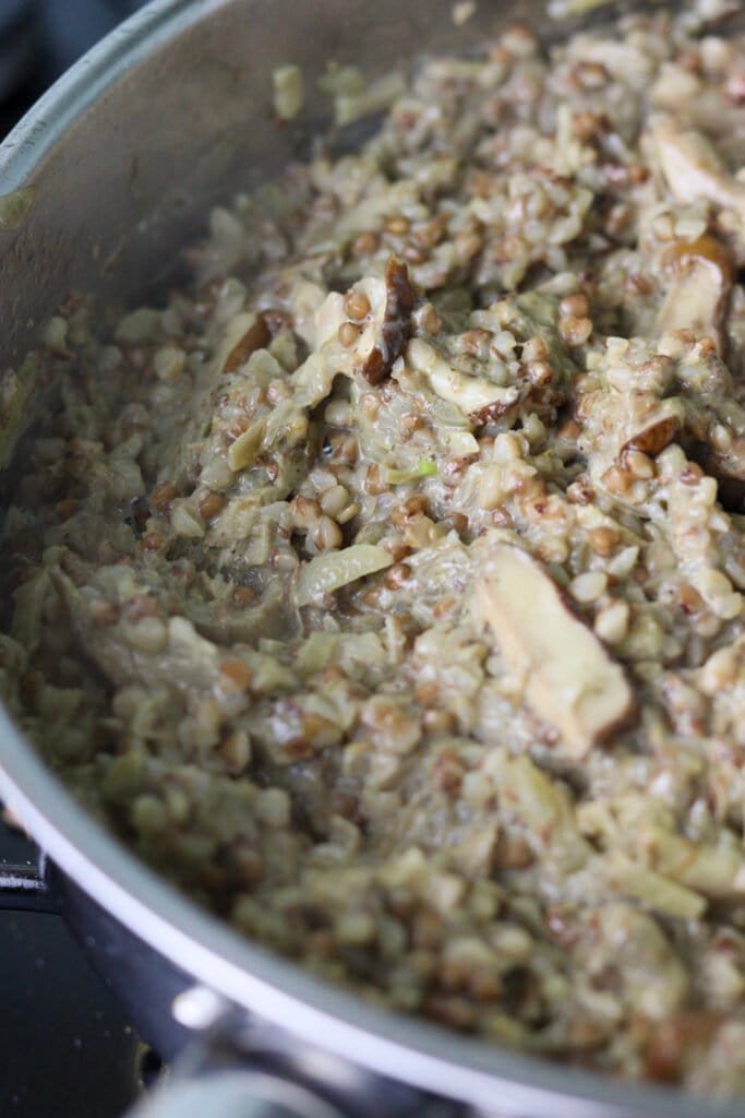 Buckwheat groats with creamy porcini in a sauce pan, just before being served.
