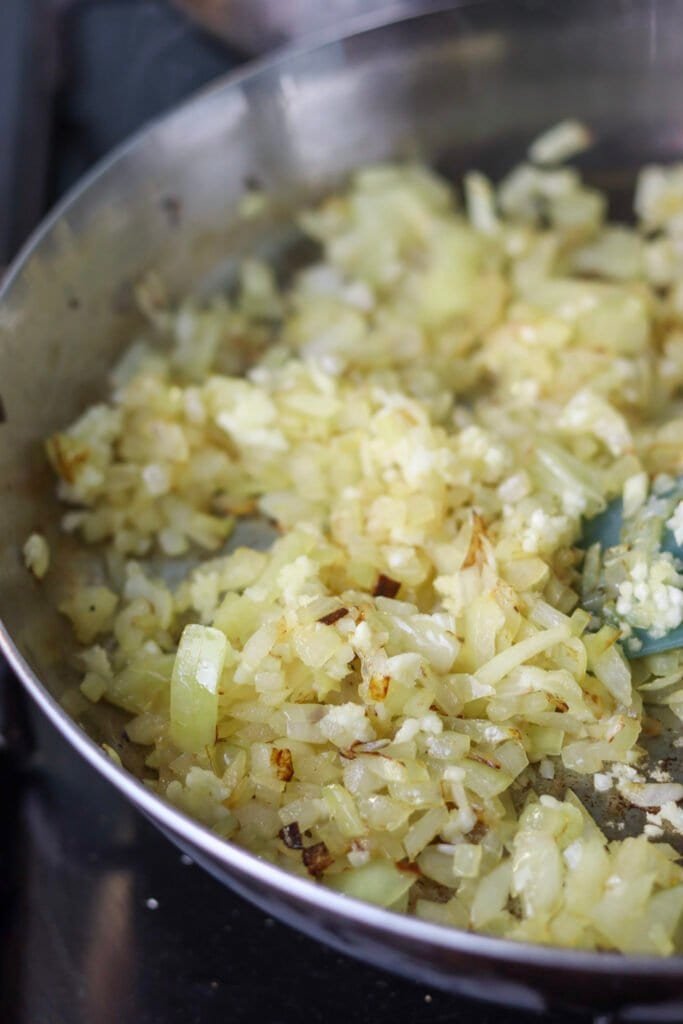 Fried onions with fresh garlic in a frying pan.