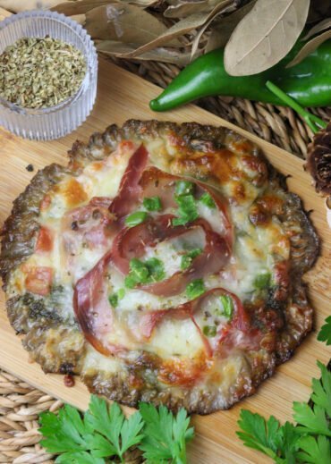 Delicious parasol mushroom pizza on a parasol mushroom crust, topped with tomato, pepper, mozzarella, pesto and prosciutto.