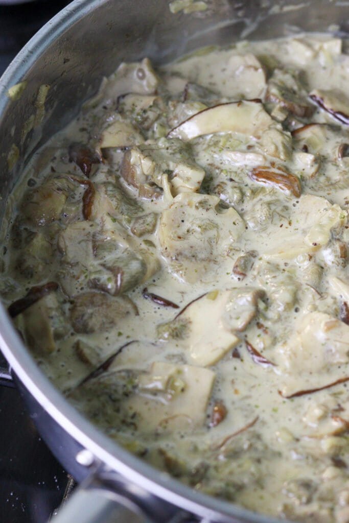 Porcini mushrooms in a sauce pan with heavy cream and added marjoram and thyme.