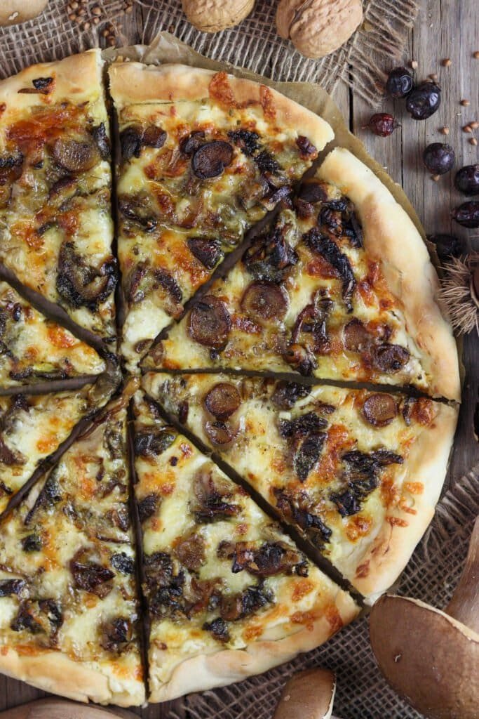 A close view of porcini pizza with mozzarella, cheddar and porcini mushrooms and a golden brown crispy crust.