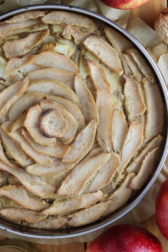 The cake just baked, still in a pan, with golden brown baked apple and pear slices on top.