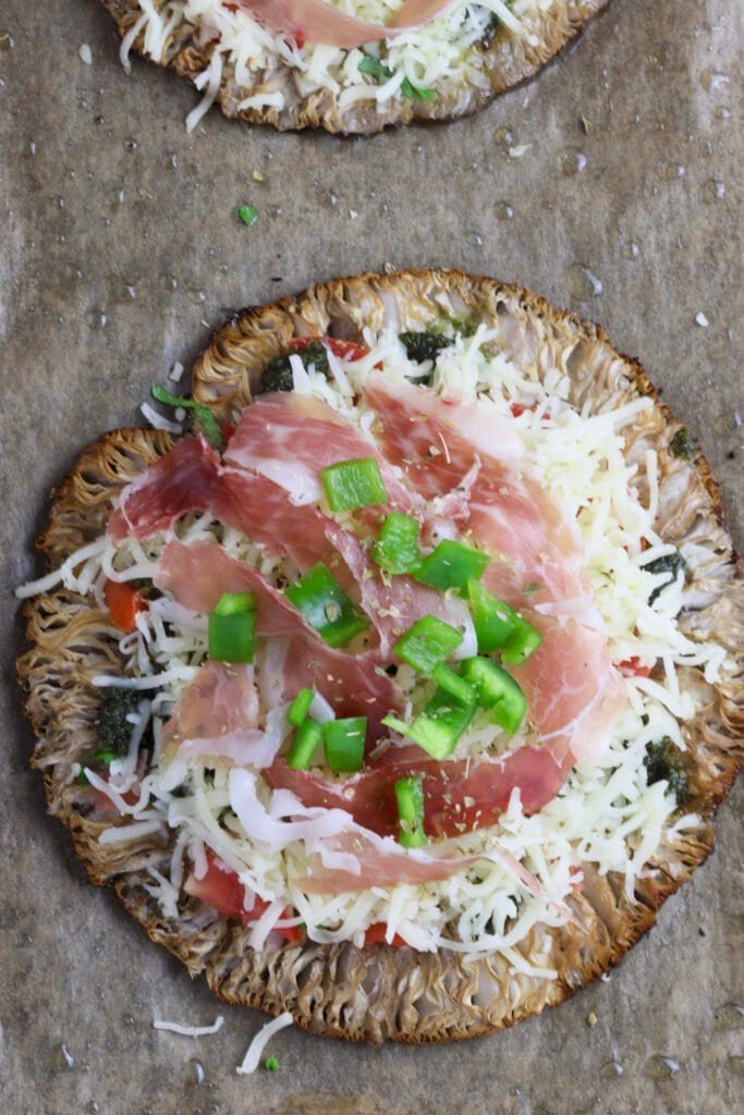 Topping the mushrooms with green pepper on top of prosciutto..