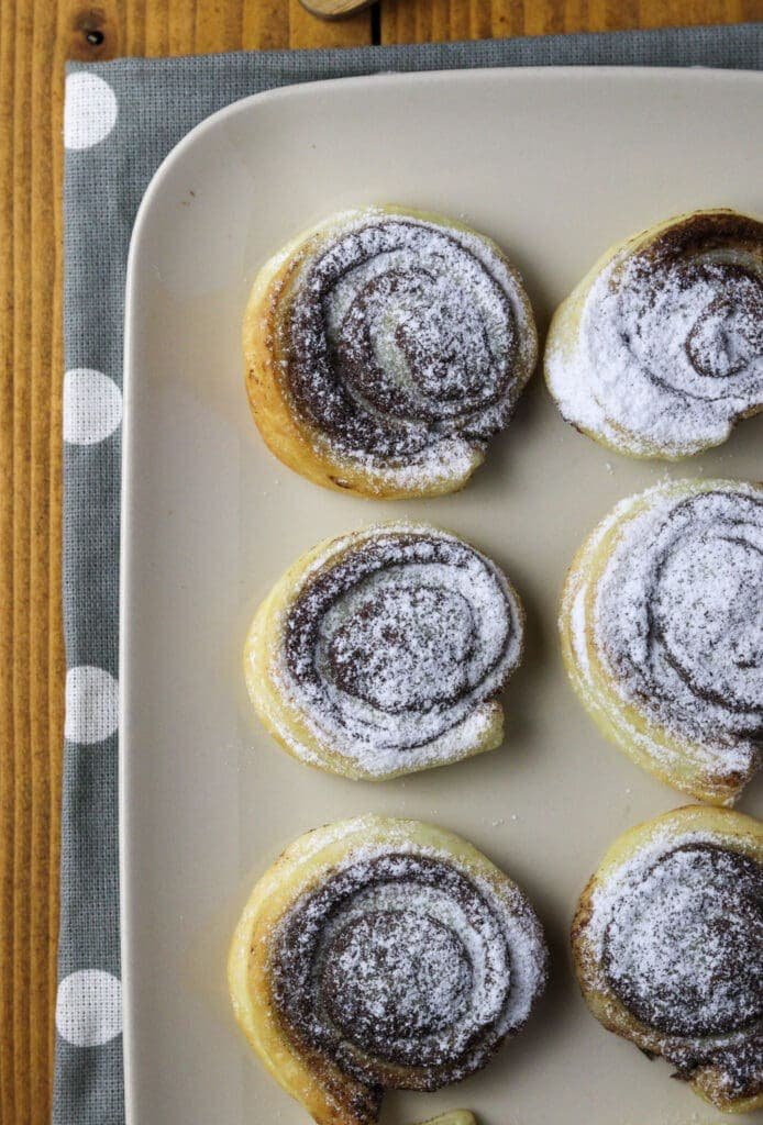 image showing puff pastry cinnamon pinwheels on a white plate