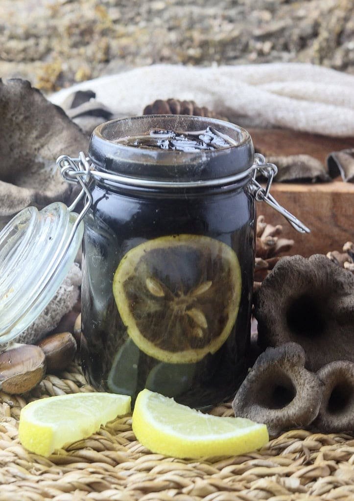image of black trumpet mushroom jam canned in a jar with lemon slices