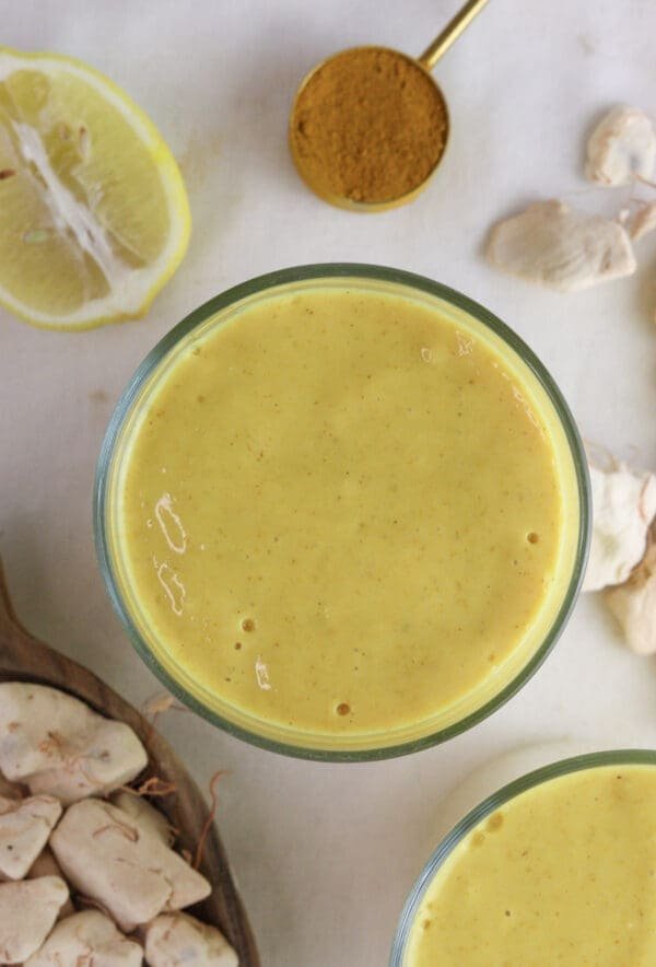Image of a glass of baobaob smoothie with giinger and baobab fruit pulp in the background