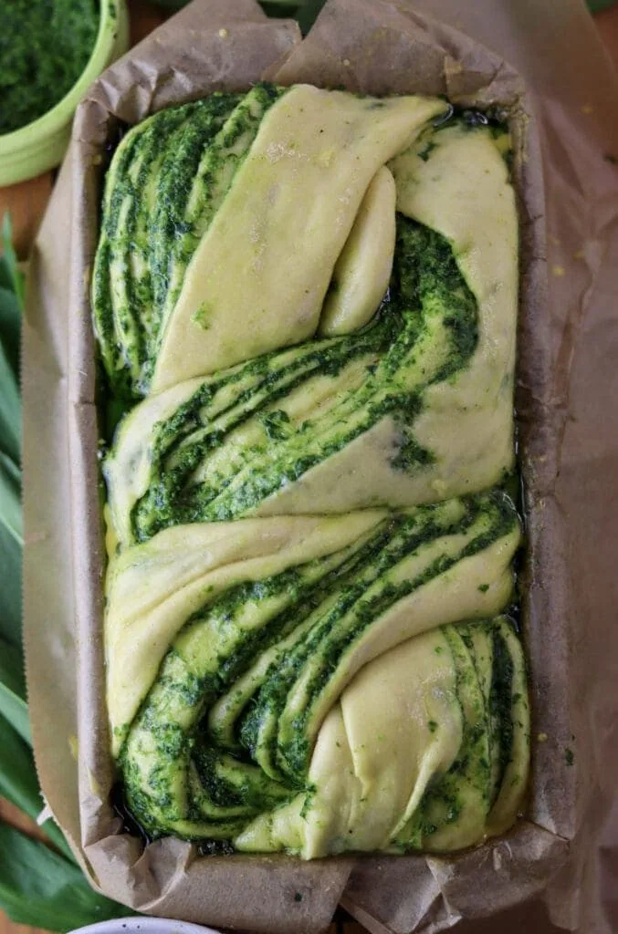 Wild garlic pesto babka loaf placed in a loaf baking pan, just before going into the oven.