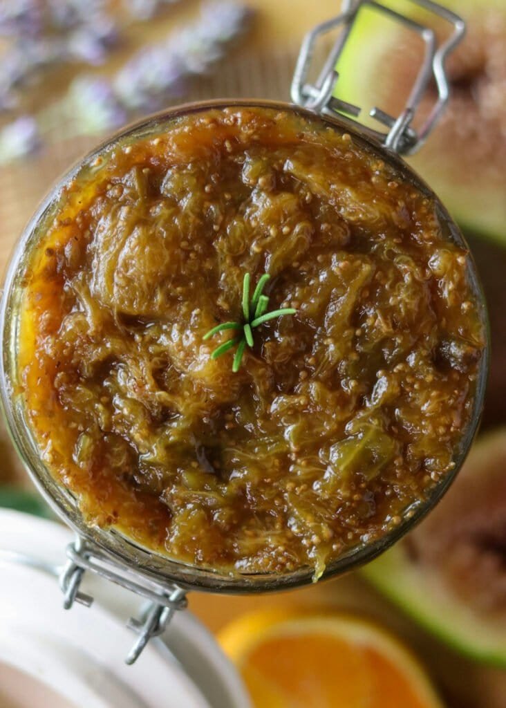 Close-up of no sugar fig jam in a jar, fresh figs, orange and lavender sprigs nearby