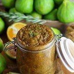Shelf-stable sugar-free fig jam in a jar, prepped for canning with rosemary and orange zest, fresh figs in the background.