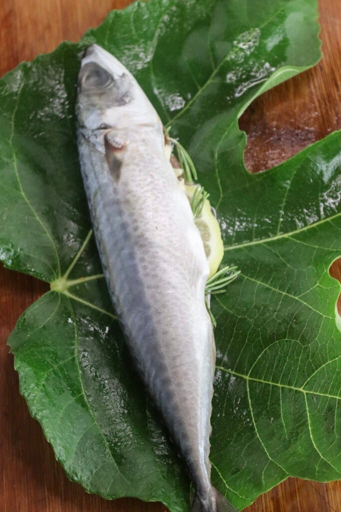 Spiced and stuffed chub mackerel on a large fig leaf.