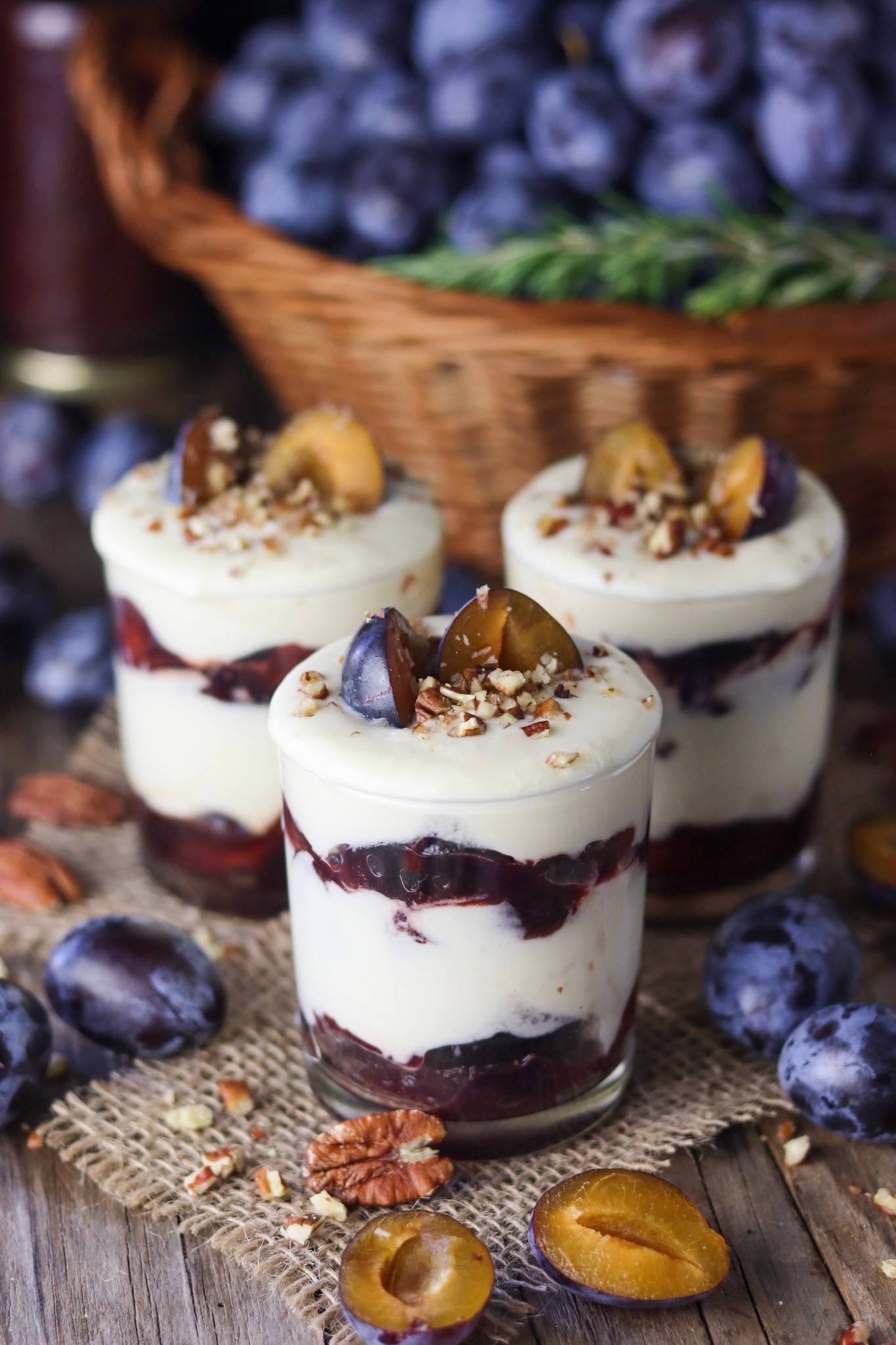 Roasted plum parfait with white chocolate on a wooden rustic table.
