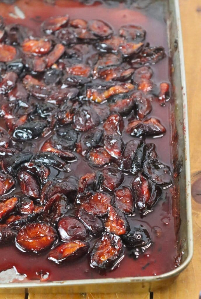 Roasted plums on a baking tray, cooling to be used for the parfait.